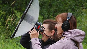 Two women recording sounds with parabolic microphone